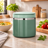 Pot alimentaire isotherme vert fermé sur un plan de travail de cuisine