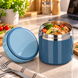 Pot repas isotherme bleu ouvert, rempli de riz et de légumes, avec son couvercle à côté